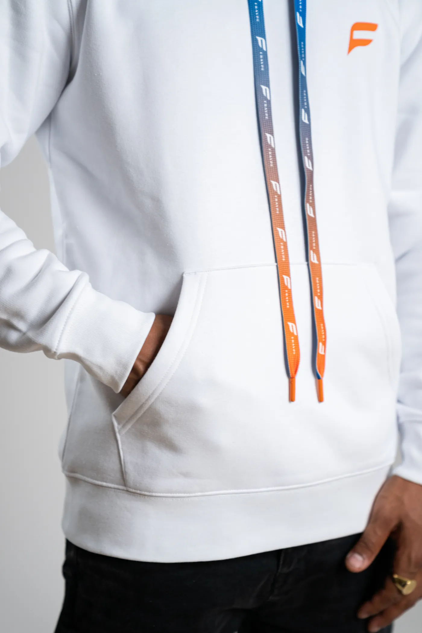 Kordeln am weissen Hoodie neben der Tasche